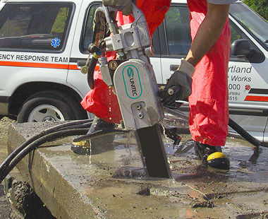 Hydraulic chain saw cutting slab of concrete