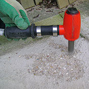 Hand-held low-vibration concrete scabbler